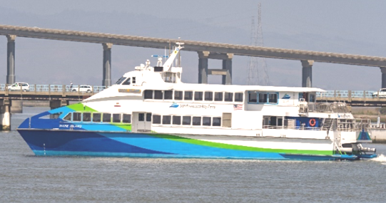 A picture of the MV Mare Island, a ferry boat in the San Francisco Bay Ferry fleet, sailing across the San Francisco Bay. It has a blue, green and white paint job and the San Francisco Bay Ferry logo adorns the side of the vessel.