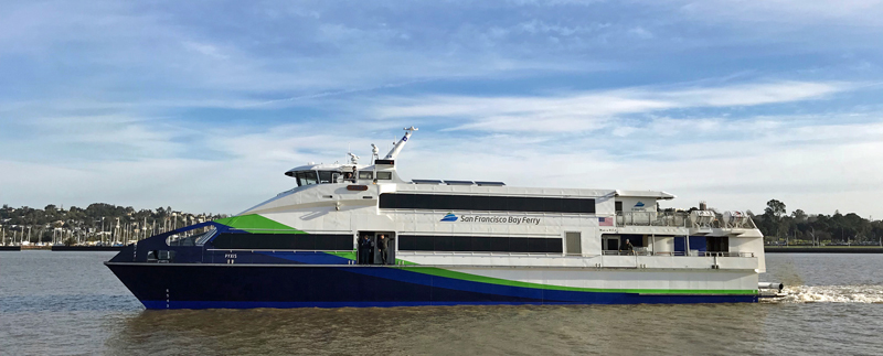 A side view of the MV Pyxis, a ferryboat belonging to the San Francisco Bay Ferry fleet. It has a blue, green and white paint job and the San Francisco Bay Ferry logo is on the side.