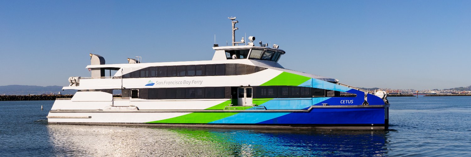 A side profile view of a blue, green and white ferry named Cetus owned and operated by San Francisco Bay Ferry.